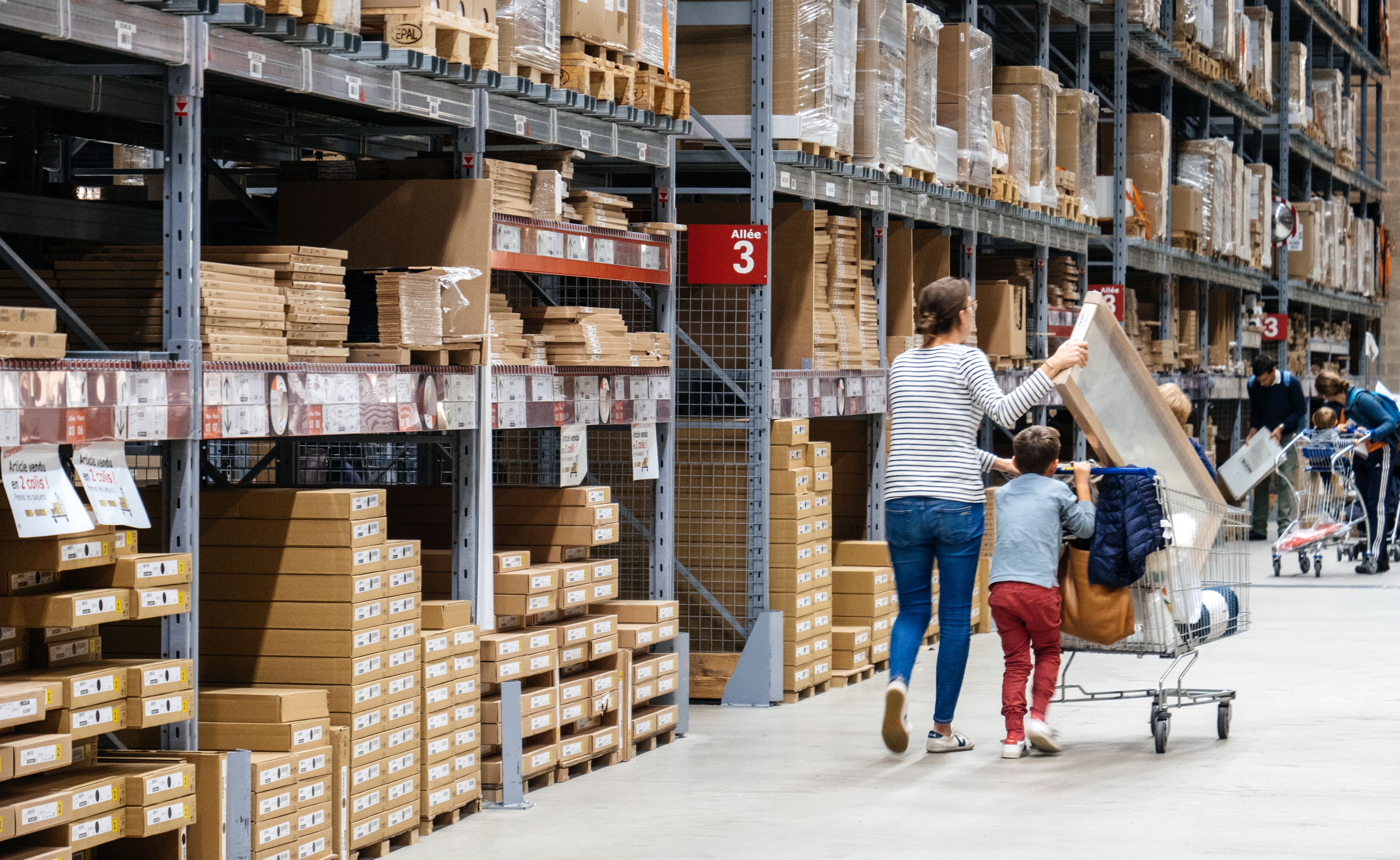 Mother and child shopping in an IKEA warehouse aisle