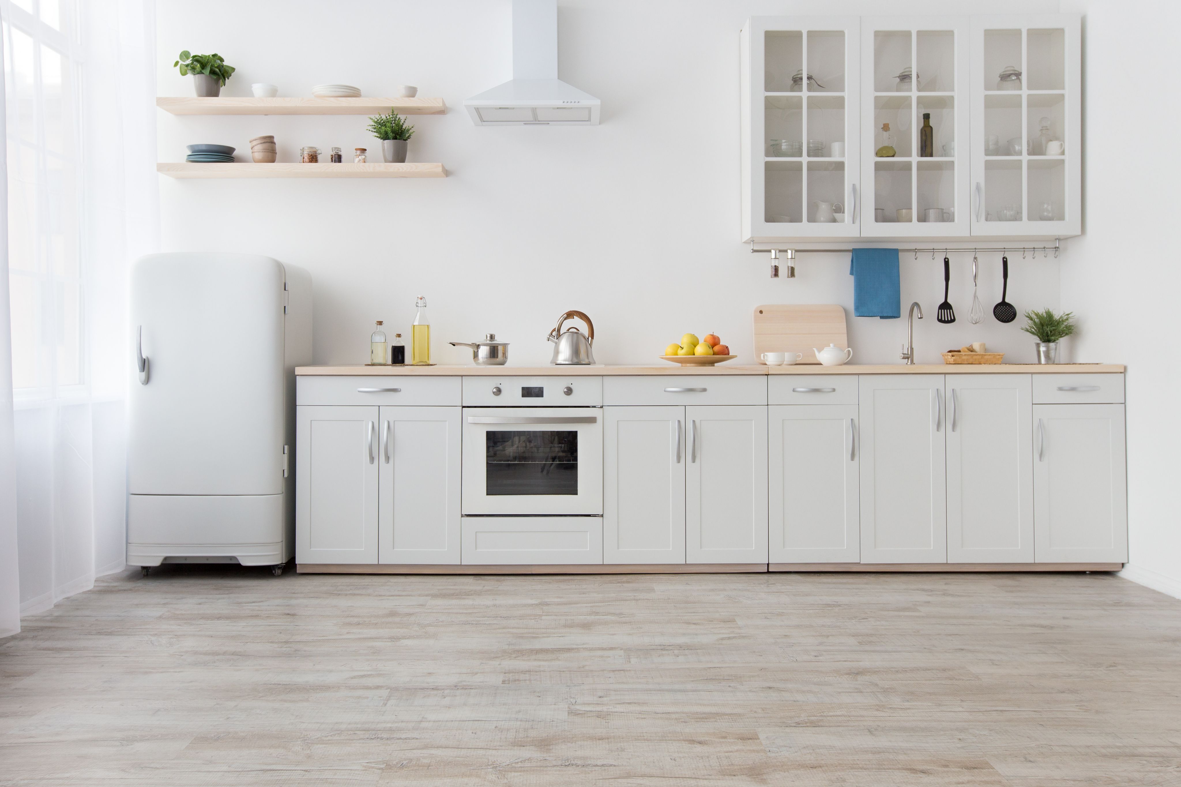Bright modern IKEA kitchen interior with white cabinets and wooden countertop