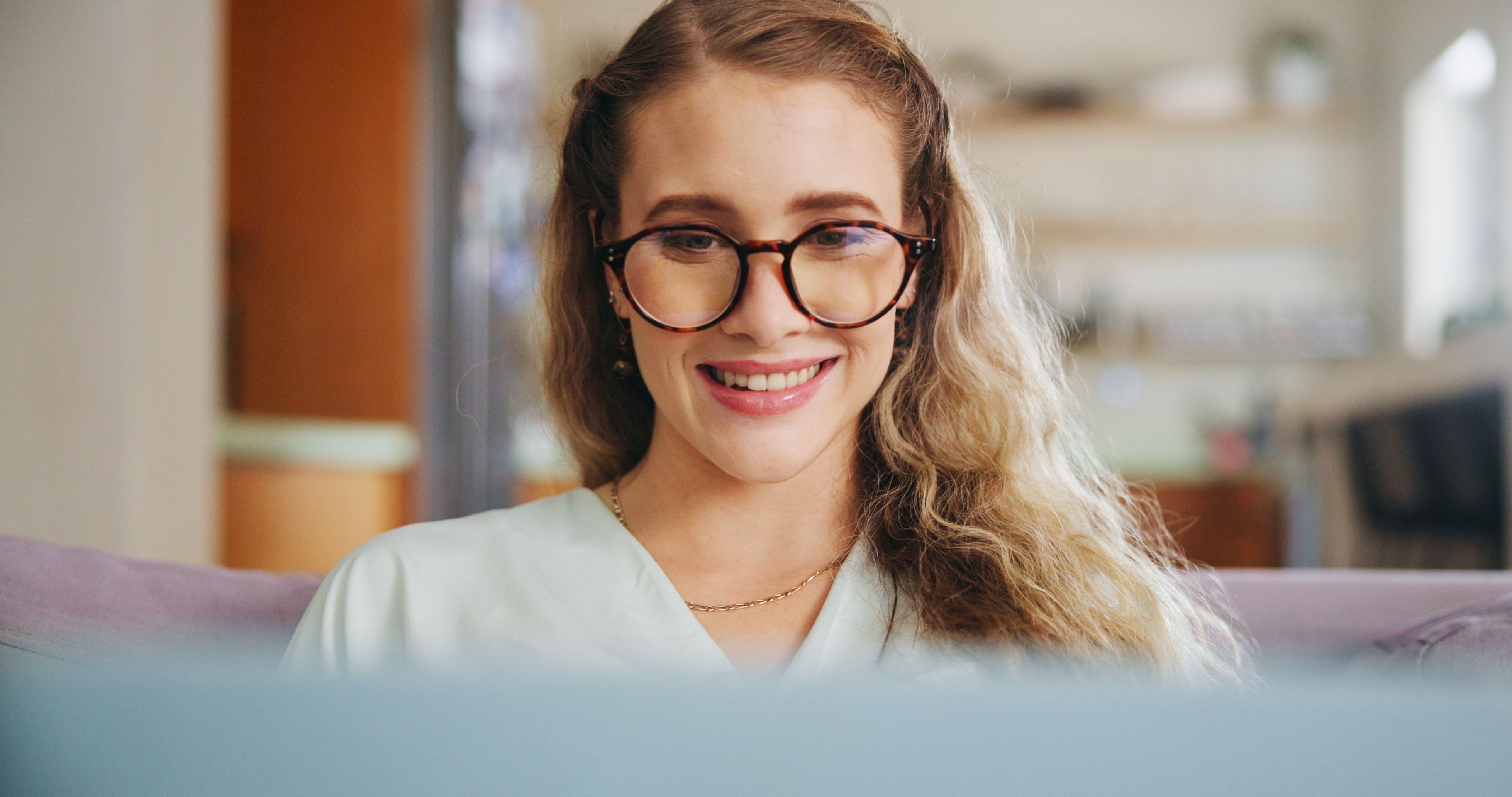 Student smiling while studying on a computer